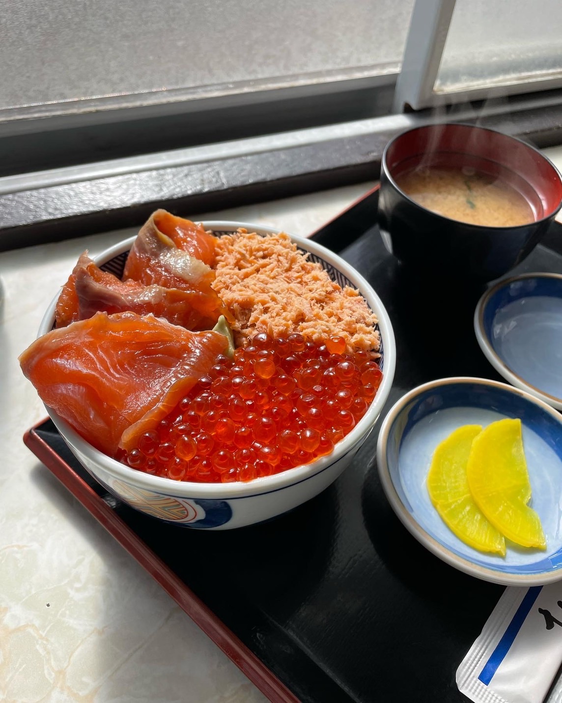母ちゃん食堂の秋鮭三種丼。鮭・いくら・鮭フレークがたっぷり盛られた丼